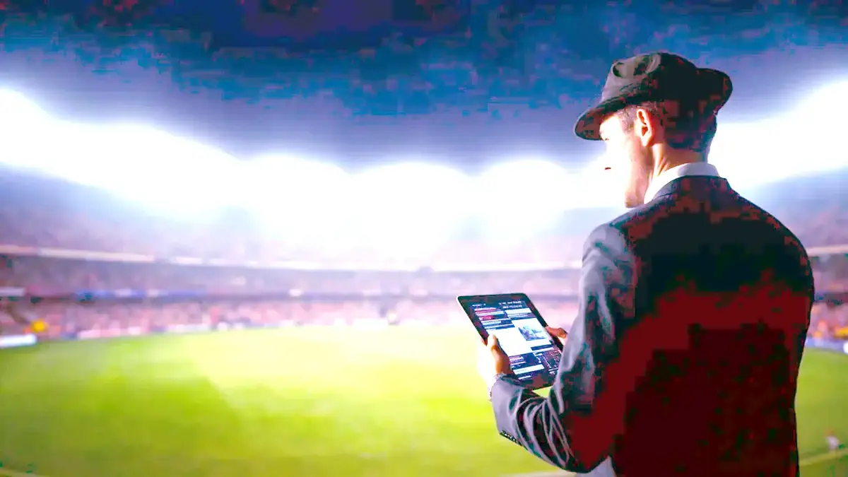 An analyst reviews match data on a tablet beside a floodlit cricket ground